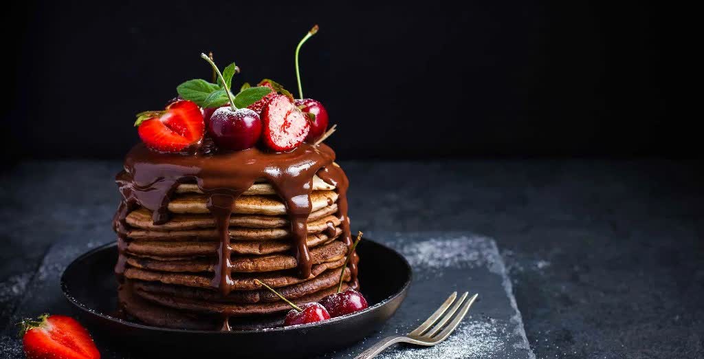 Stack of chocolate pancakes with cherries